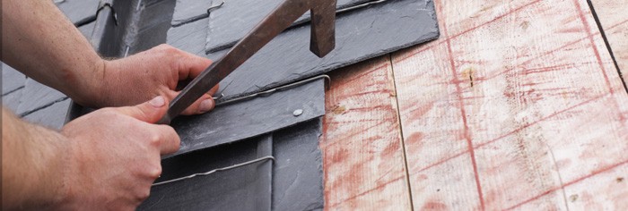 Roofer fitting new slate tiles